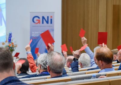 Viele Hände strecken rote Karten in die Luft